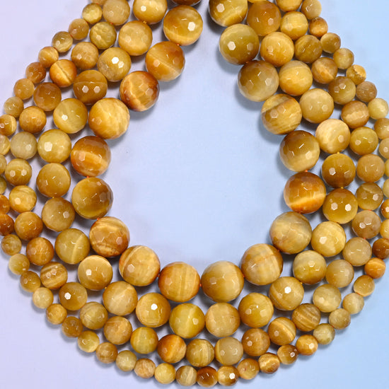 Golden brown gold tiger eye faceted round beads photographed at an angle to show natural luster.