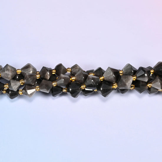 Silver obsidian bicone beads shown as a single strand laid straight across, darker near-black beads beside paler silvered ones.
