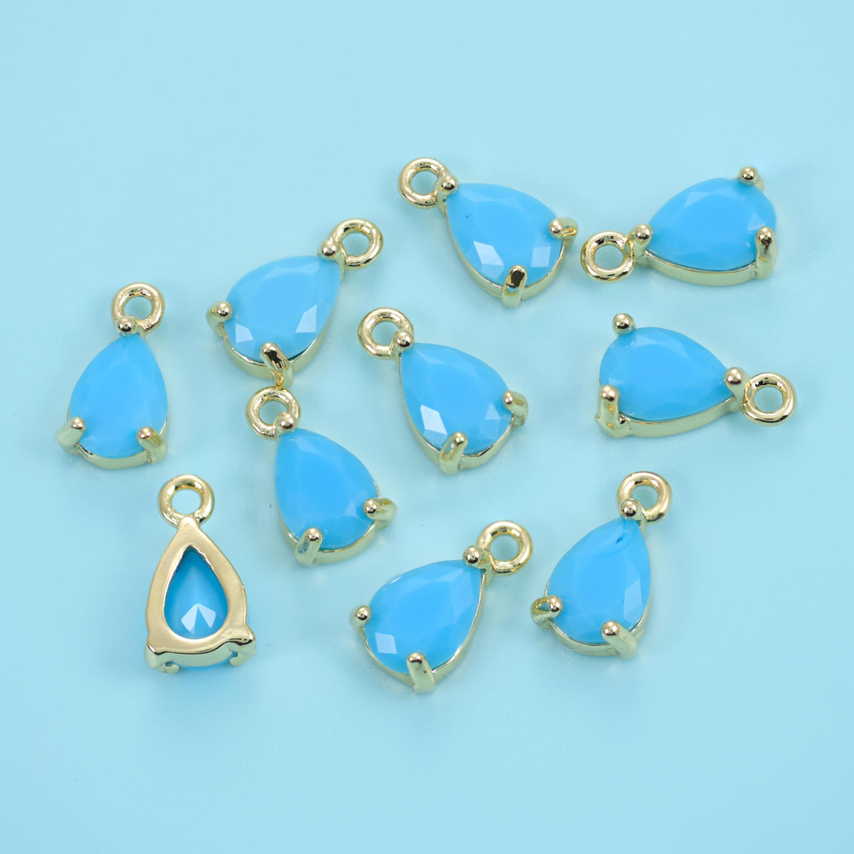 Teardrop zirconia charms in sky blue, opaque pale blue pear-cut stones.