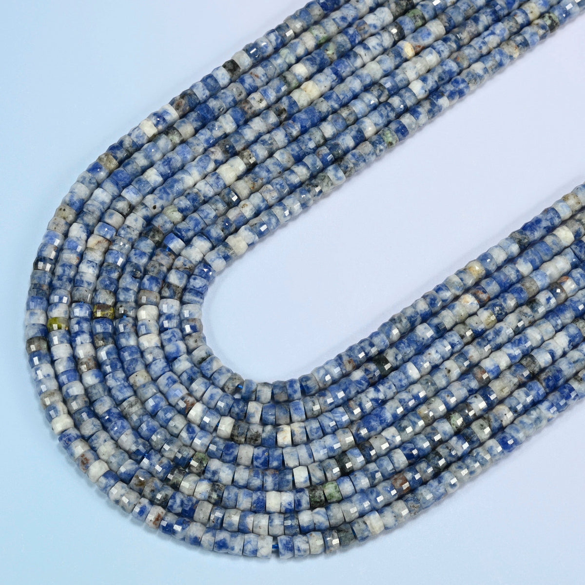 Blue spot jasper faceted heishi disc beads in several strands curved into a wide U, white stone with blue spots