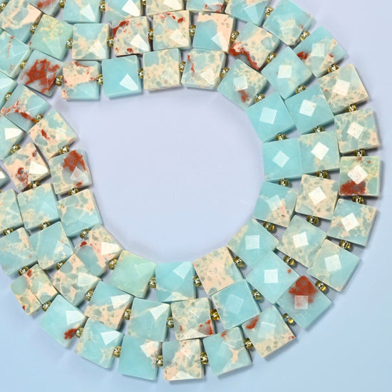 Dyed blue Shoushan stone faceted flat square beads curved into an open loop, light blue beads with cream and red-brown matrix