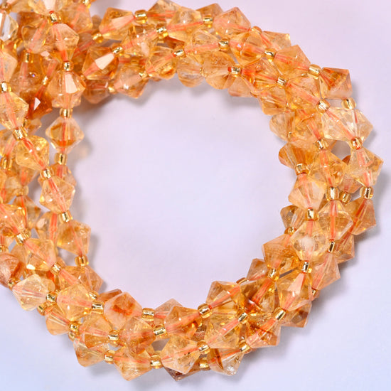 Citrine bicone beads coiled into a round ring of several strands, a warm golden glow running the length of the strand.