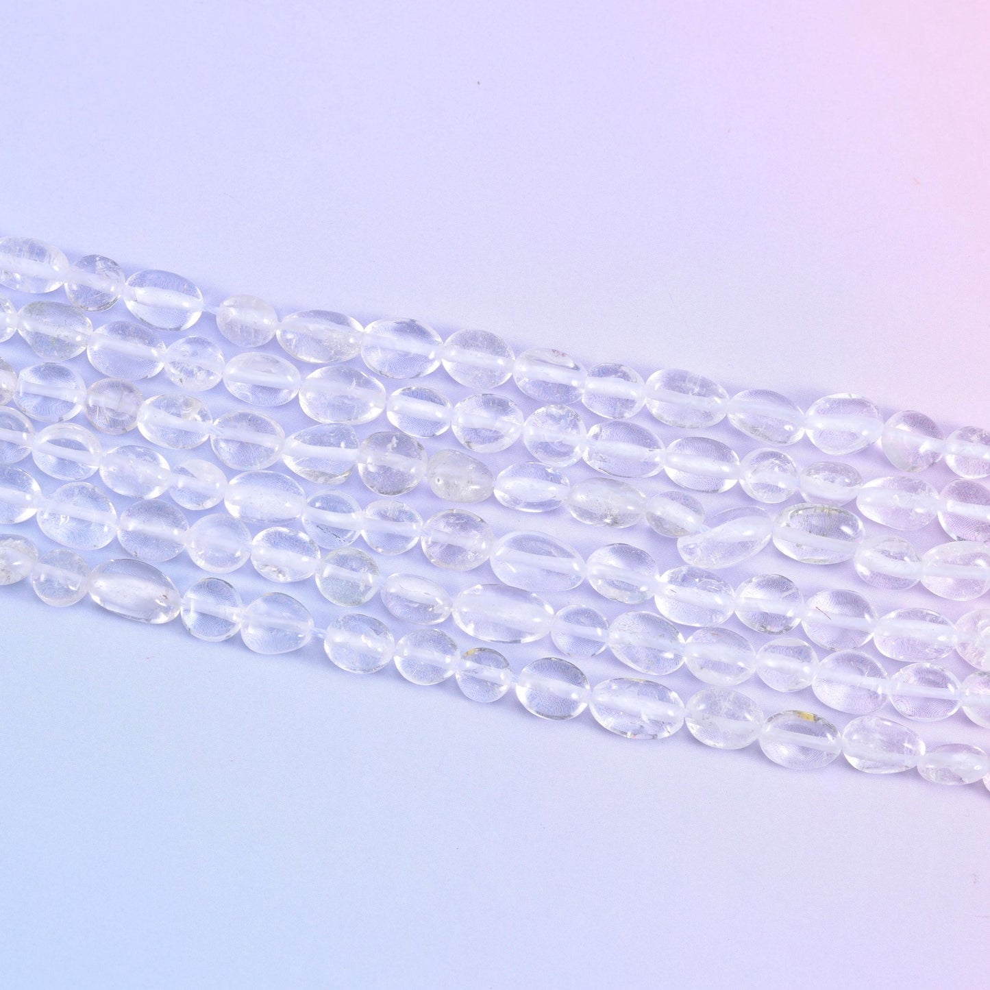 Strands laid flat, tumbled nuggets showing their varied lengths along each row