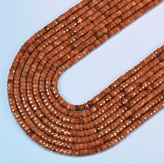 Gold sandstone faceted heishi disc beads in several strands curved into a wide U, copper brown glass with fine gold glitter