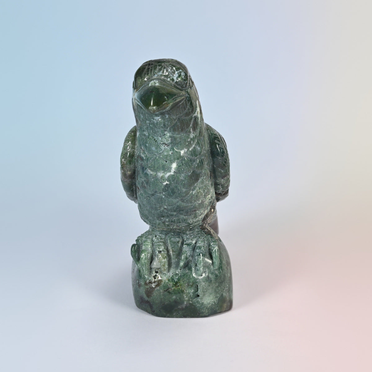 Front view of the Indian agate crow perched on its carved rock base