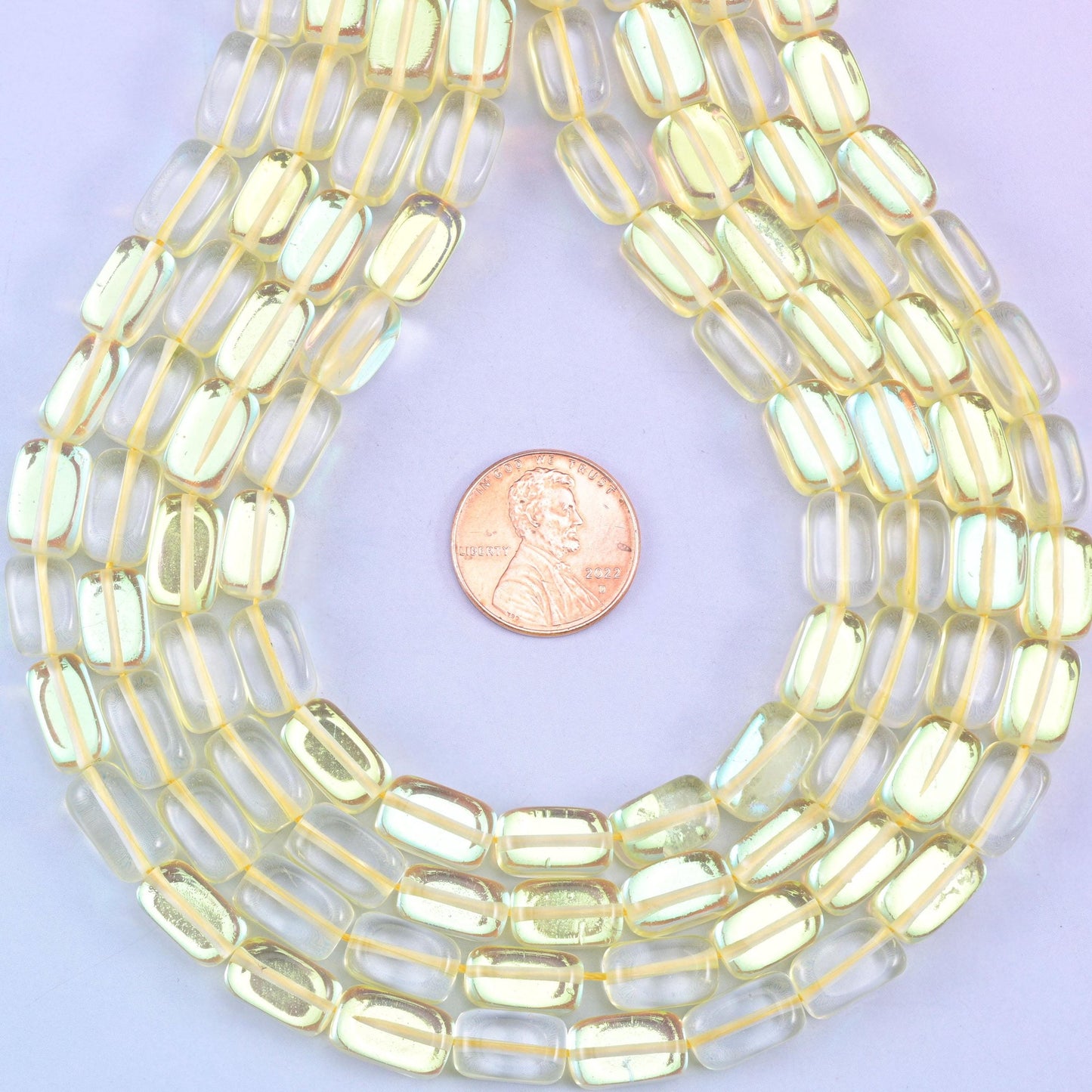 Yellow Mystic Aura glass beads in a rectangular cut with a glossy transparent finish, featuring a sunny golden-yellow shine with a subtle iridescent glow