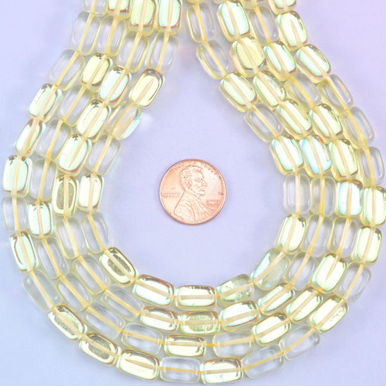 Yellow Mystic Aura glass beads in a rectangular cut with a glossy transparent finish, featuring a sunny golden-yellow shine with a subtle iridescent glow
