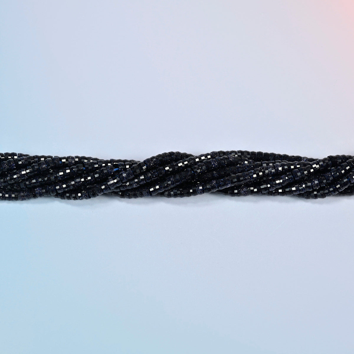 Strands of blue sandstone faceted heishi disc beads twisted together in a horizontal row