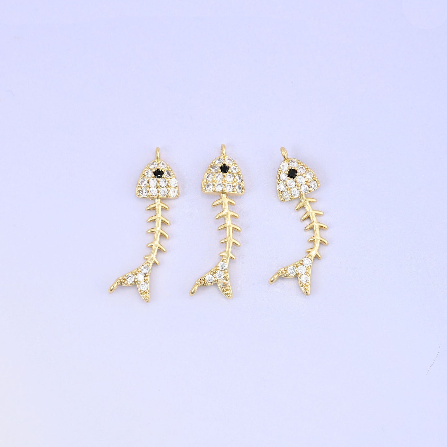 Brass fishbone charm with sleek zirconia accent