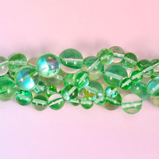 Clear apple-green glass beads finished with an iridescent aura coating