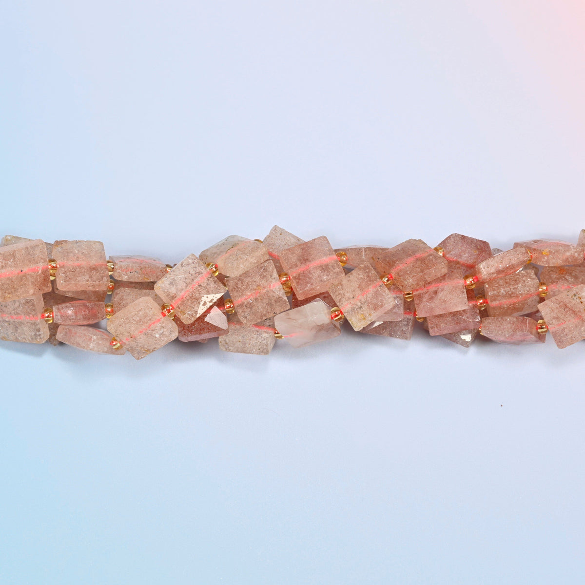 Strands of natural strawberry quartz faceted flat square beads twisted together in a horizontal row