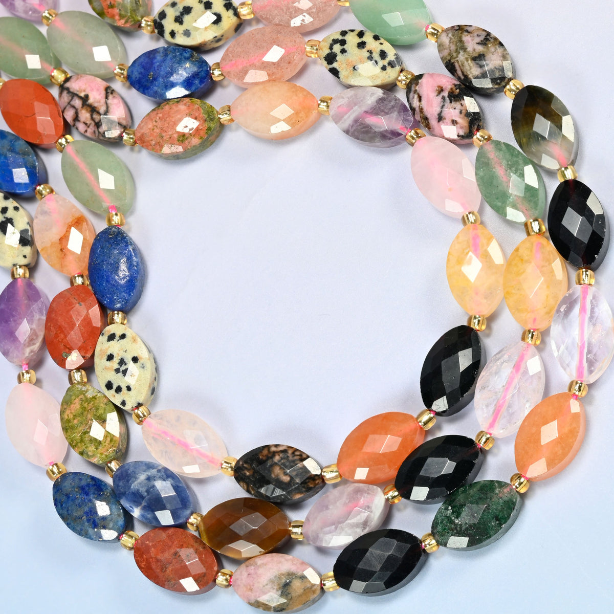 Assorted gemstone faceted flat oval beads curved into an open loop, assorted stones in many colors