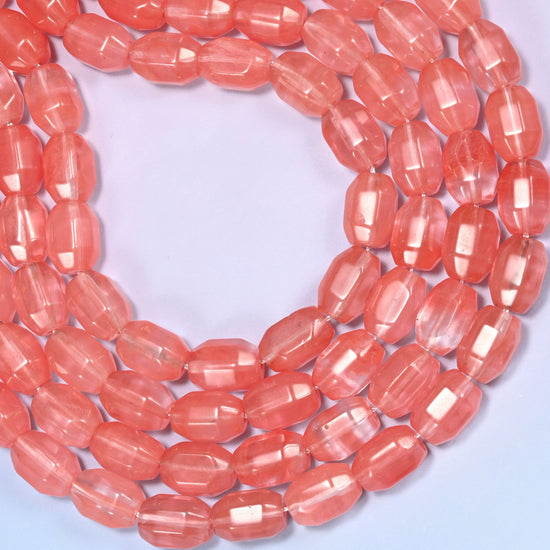 Close-up of a dense circular coil of coral pink faceted glass barrel beads, showing the translucent color depth.