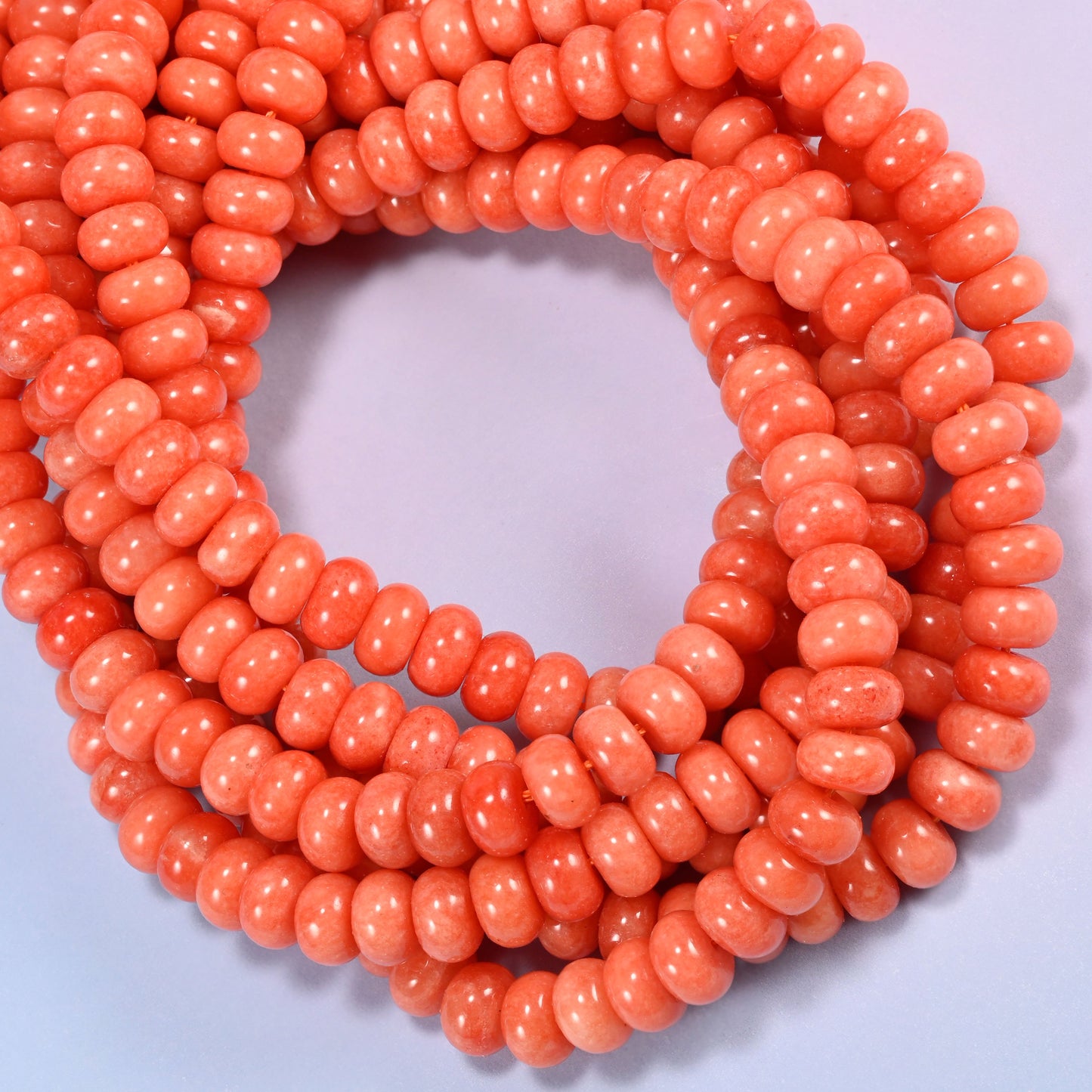 Red Orange dyed jade gemstone rondelle beads coiled into a ring, even warm orange across the whole strand