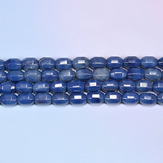 Close-up rows of blue faceted Aventurine barrel beads laid flat, showing the mix of deep royal blue and lighter blue-grey tones.