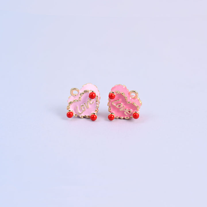 A pair of enamel heart charms, light pink and pink, 18K gold plated with scalloped gold edging and small red beads.