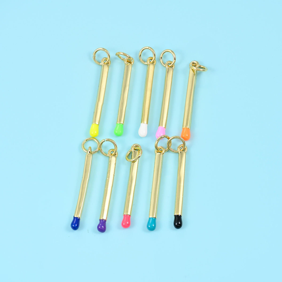 Matchstick pendant colourway lineup of ten pieces in yellow, green, white, pink, orange, navy, purple, red, pink and black, arranged in two rows.