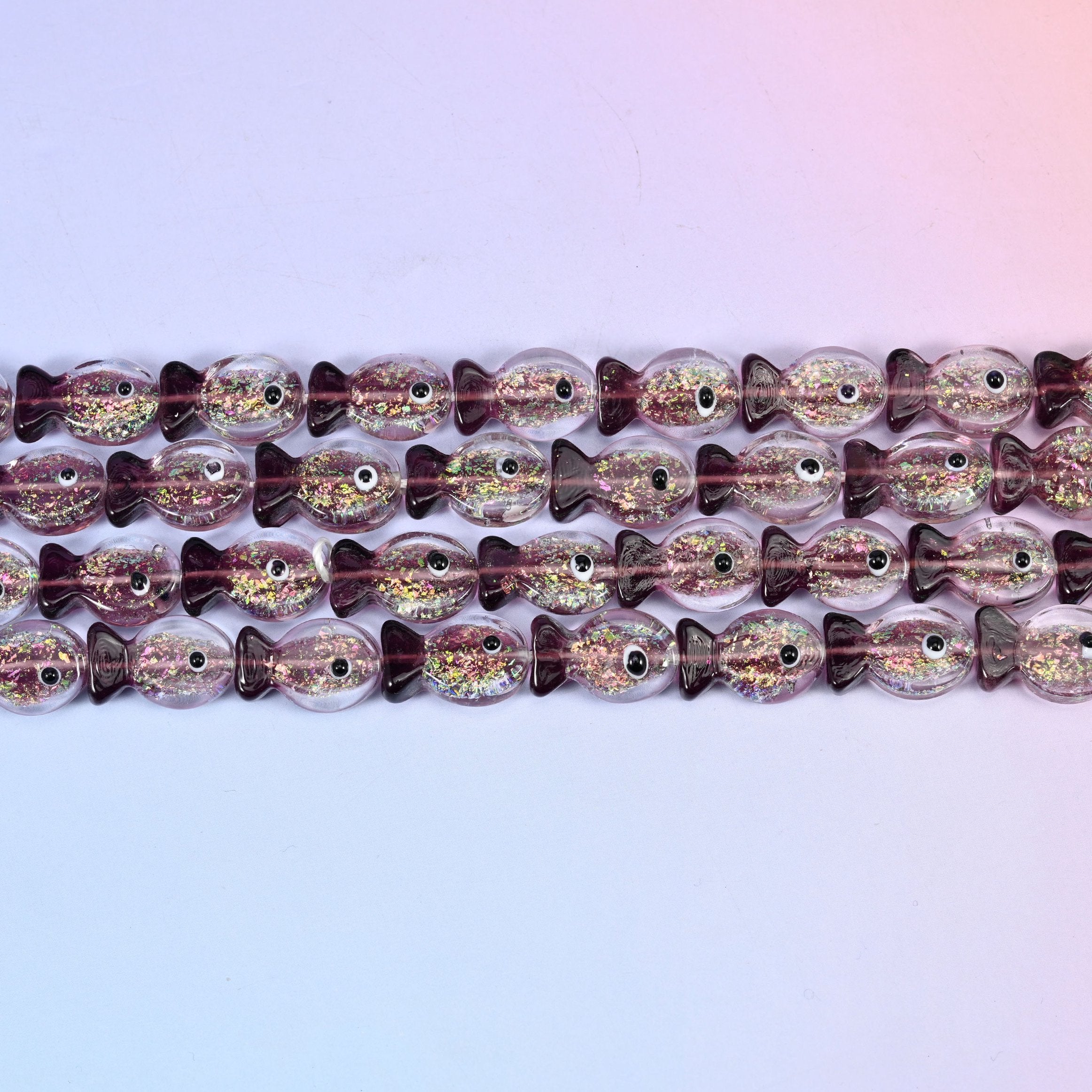 Iridescent purple fish glass beads in amethyst-tinted glass with green and gold glitter foil