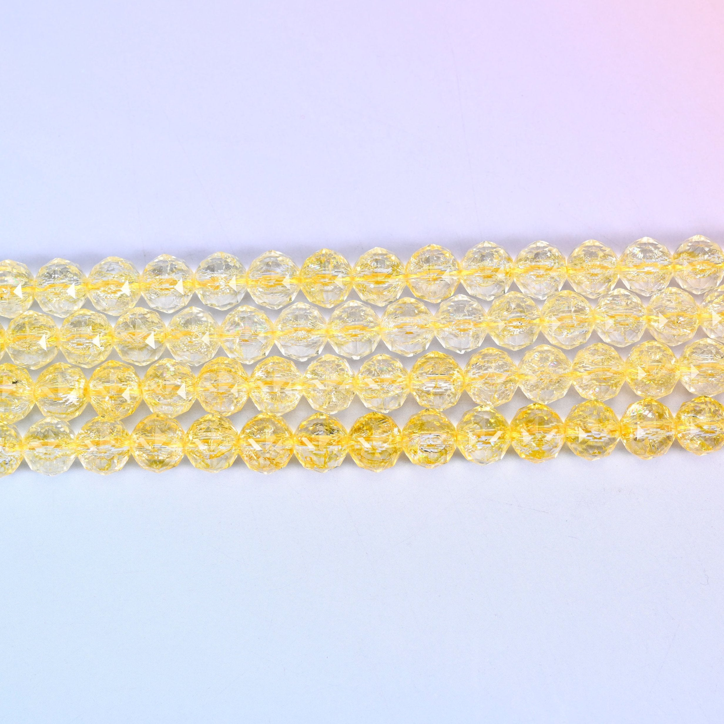 Transparent yellow faceted round glass beads in clear lemon-to-champagne