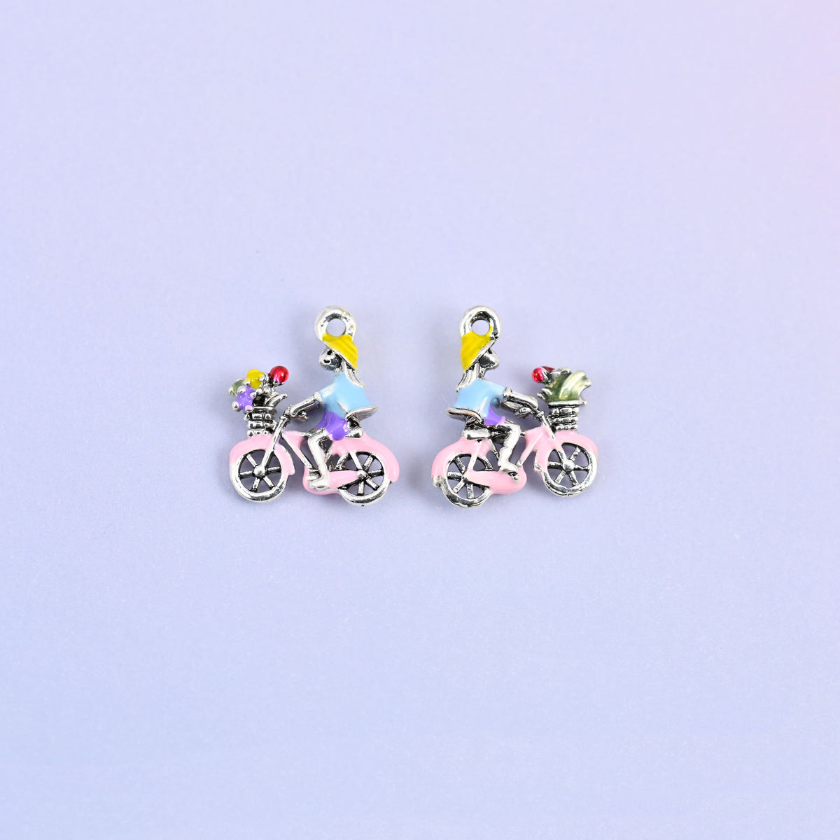 Two bicycle charms side by side, enamel detail on 18K white gold plated brass.