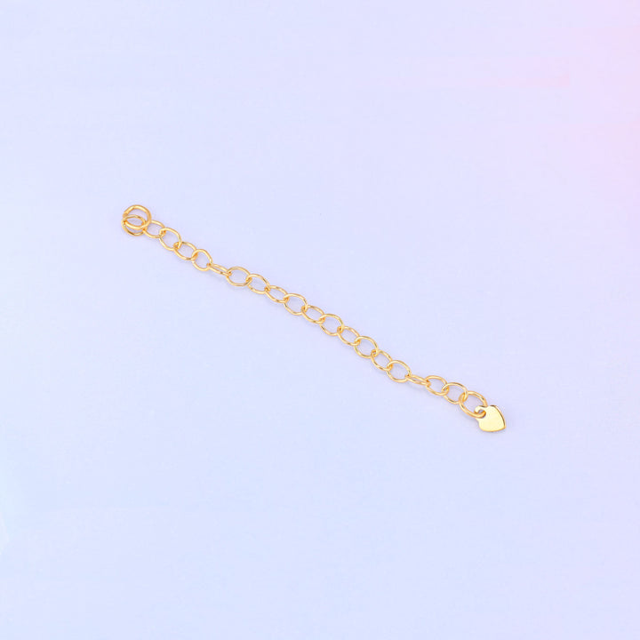 14K gold filled heart chain extender laid diagonally, cable-link chain with a jump ring loop at one end and a small heart charm at the other.