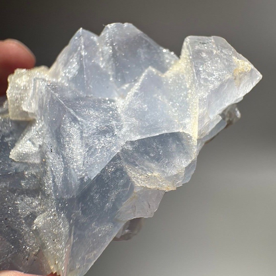 Angled view of the blue cubic fluorite, stacked crystals catching light along their straight edges