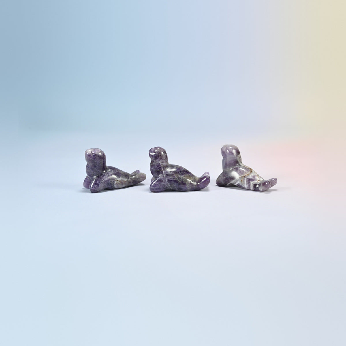 Three amethyst sea lion crystal carvings, 1.5 inch, purple and white natural stone