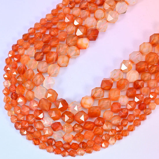 Orange Agate diamond star cut beads, strands crossing in a V, depth of orange and translucency varying bead to bead