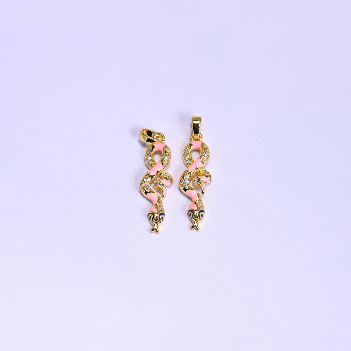 Two pink Enamel Snake Zirconia Charms side by side, coiled 18K gold plated pendants with pink enamel, zirconia pave scales and navy enamel heads.