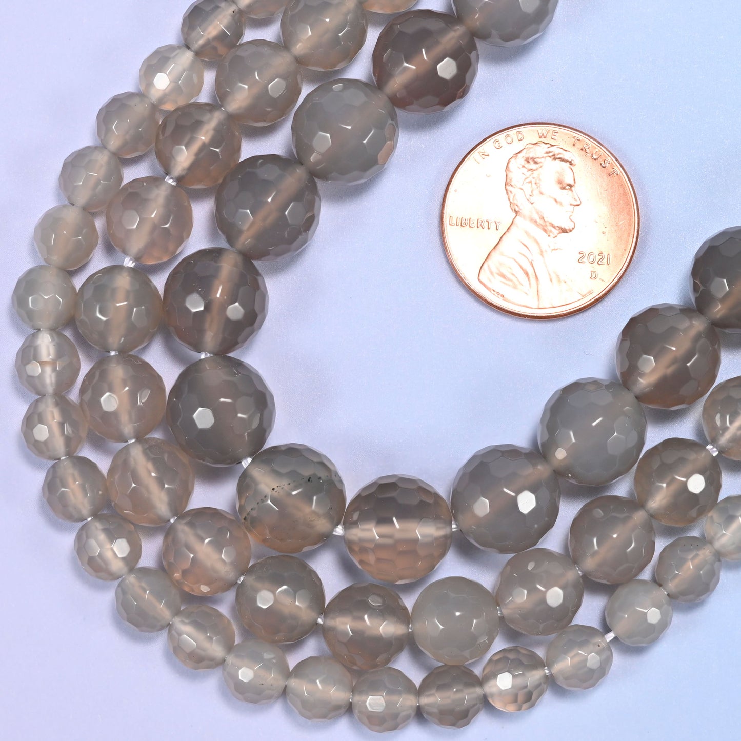 Gray agate round beads in 6mm, 8mm, and 10mm grouped together to compare sizes.