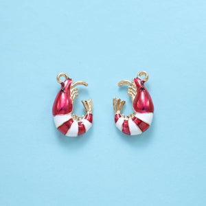 Two enamel shrimp charms in dark red enamel, curled bodies with white banded tails.