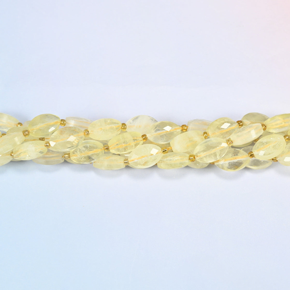 Strands of citrine faceted flat oval beads twisted together in a horizontal row