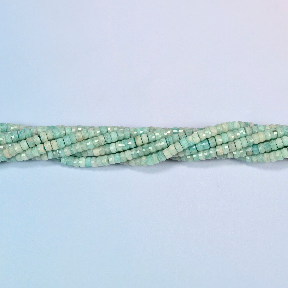 Strands of green amazonite faceted heishi disc beads twisted together in a horizontal row