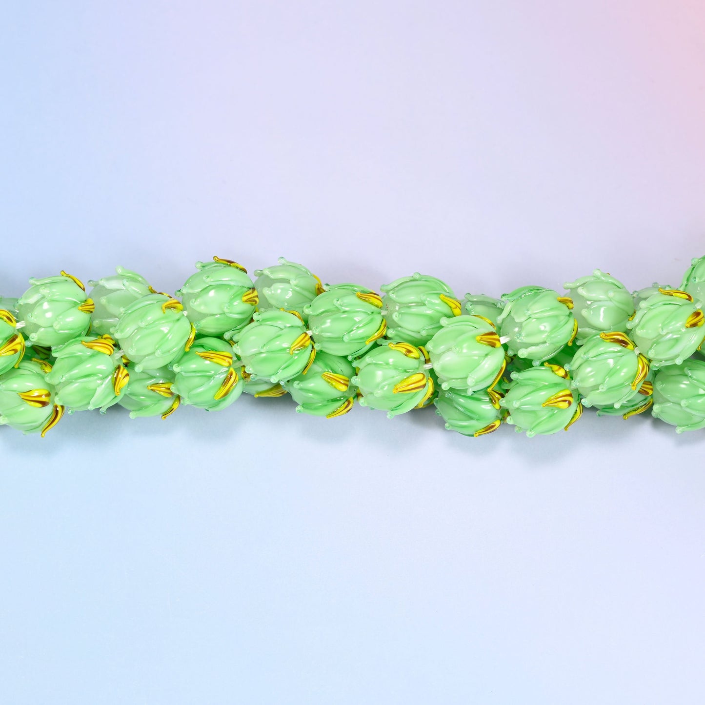 Green tulip bud-shaped lampwork glass beads, hand-formed with sculpted petal detailing that gives a realistic flower bud look, accented with a gold leaf detail at the base.