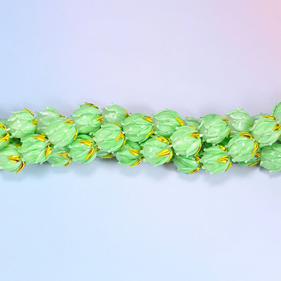 Green tulip bud-shaped lampwork glass beads, hand-formed with sculpted petal detailing that gives a realistic flower bud look, accented with a gold leaf detail at the base.