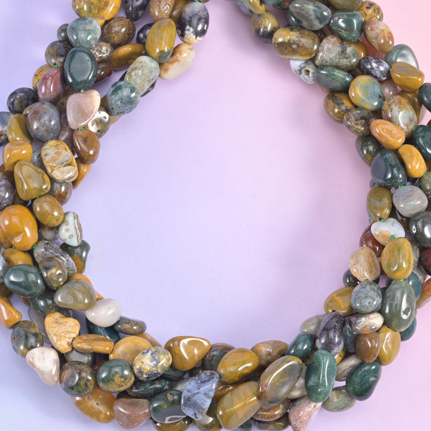 Freeform tumbled pebbles in mustard yellow, deep forest green, cream and soft rust, polished to a glassy shine