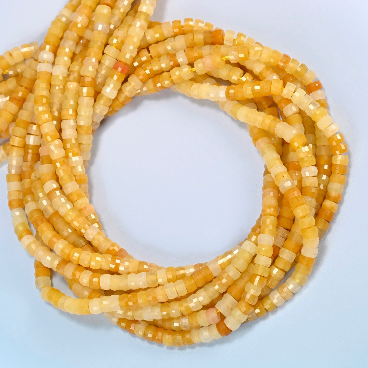 Gold Silk Jade faceted heishi disc beads coiled into overlapping loops, whole strands of warm golden yellow stone