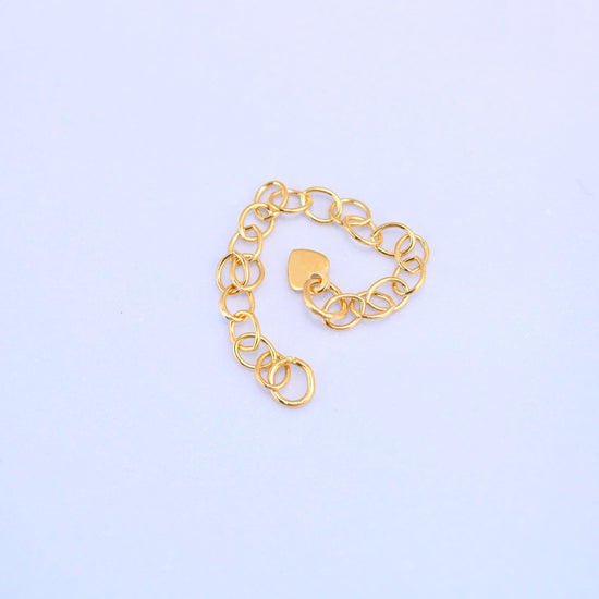 14K gold filled heart chain extender coiled loosely into a heart shape with the stamped heart charm resting in the center.