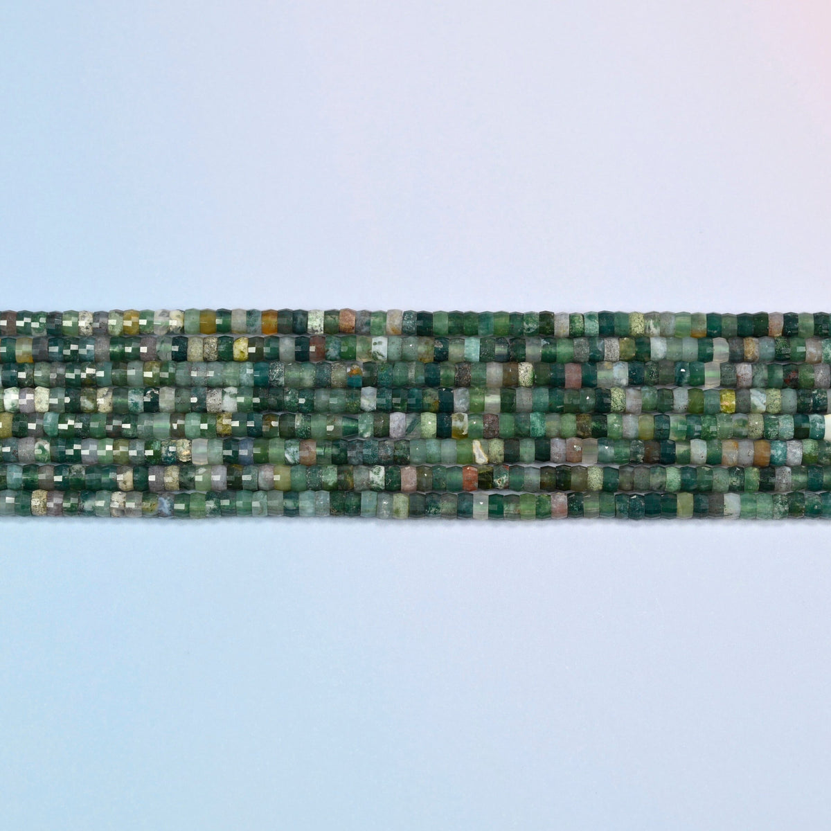 Several strands of Indian agate faceted heishi disc beads laid in straight rows