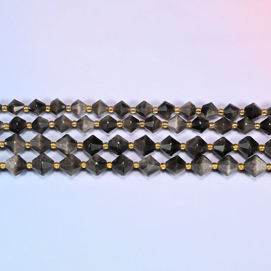 Silver obsidian bicone beads in straight rows, seen close up, each bead cut to two points meeting at a wide center.