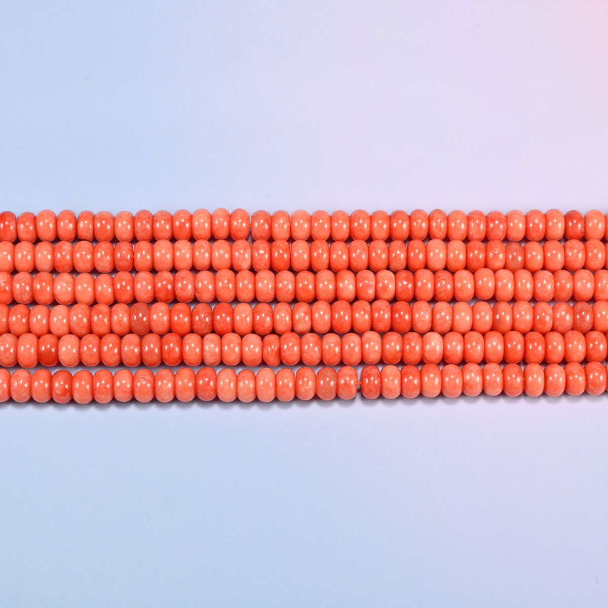Red Orange dyed jade gemstone rondelle beads in straight rows, showing the flat 5x8mm disc profile and centre drilling