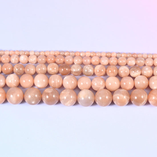 Peach Moonstone rounds, semi-opaque with a soft milky sheen under the polish.