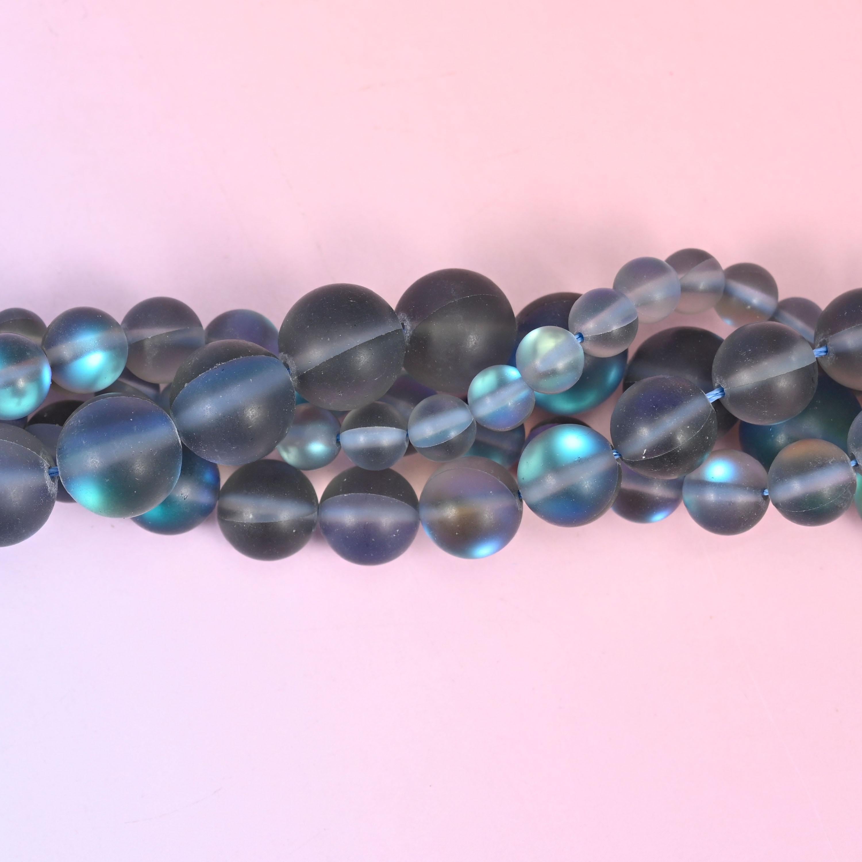 Frosted smoke grey glass beads with a soft sanded finish and aurora shimmer