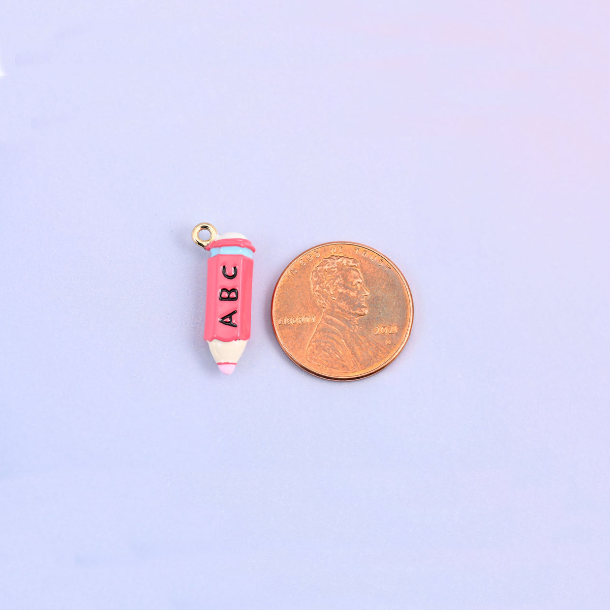 Pink pencil charm shown at actual size, 20.57 x 8.87mm.
