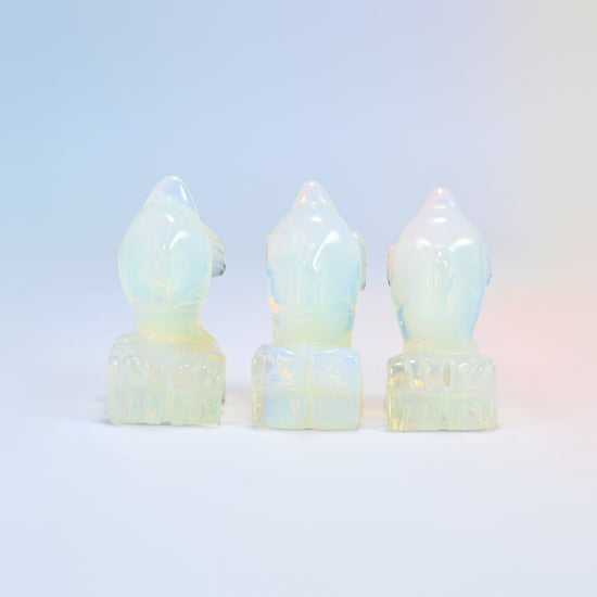 Back view of three opalite dolphin carvings showing the carved wave base
