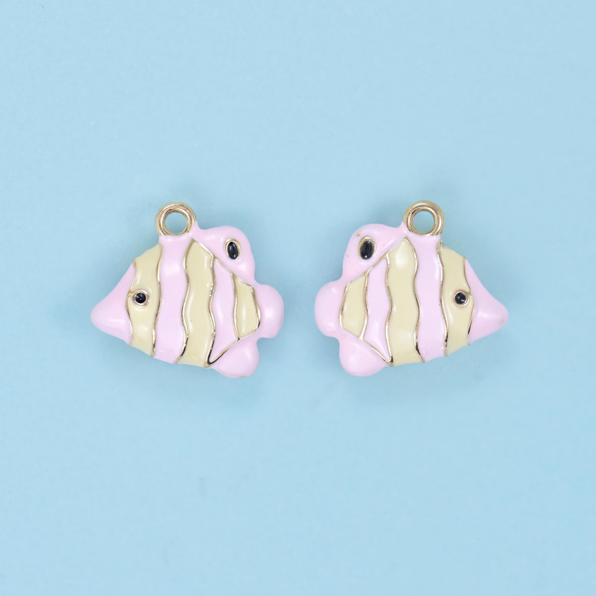 Enamel tropical fish charm in buttercream and pink stripes, shown as a pair.