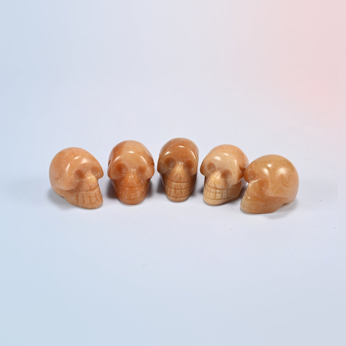 1 inch skull crystal carving in red aventurine, orange-red natural stone with a soft shimmer
