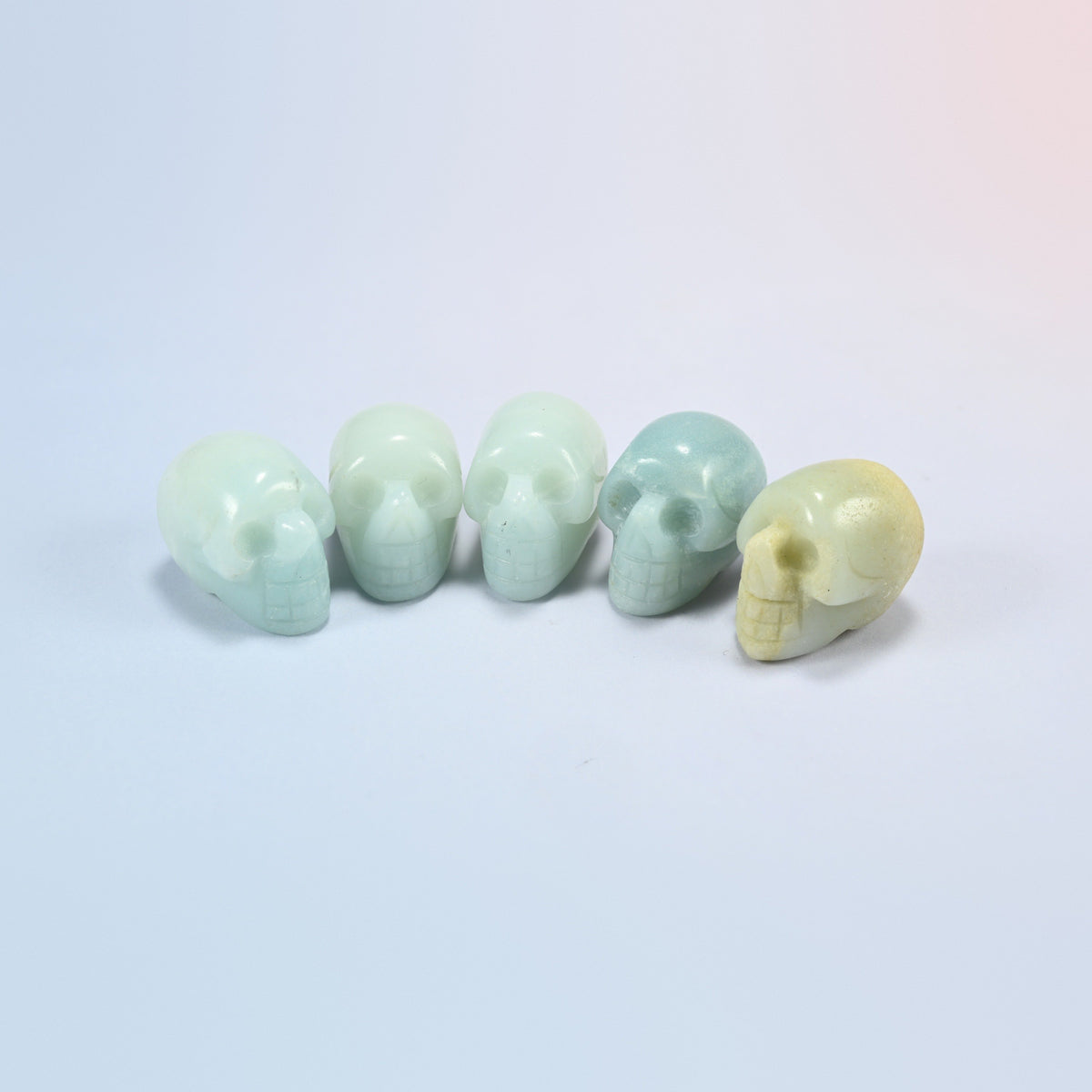 1 inch skull crystal carving in amazonite, soft green natural stone with white streaks