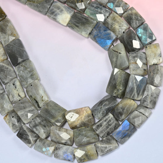 Gray Labradorite faceted flat rectangle beads curved into a wide open loop, near-white tiles beside charcoal ones