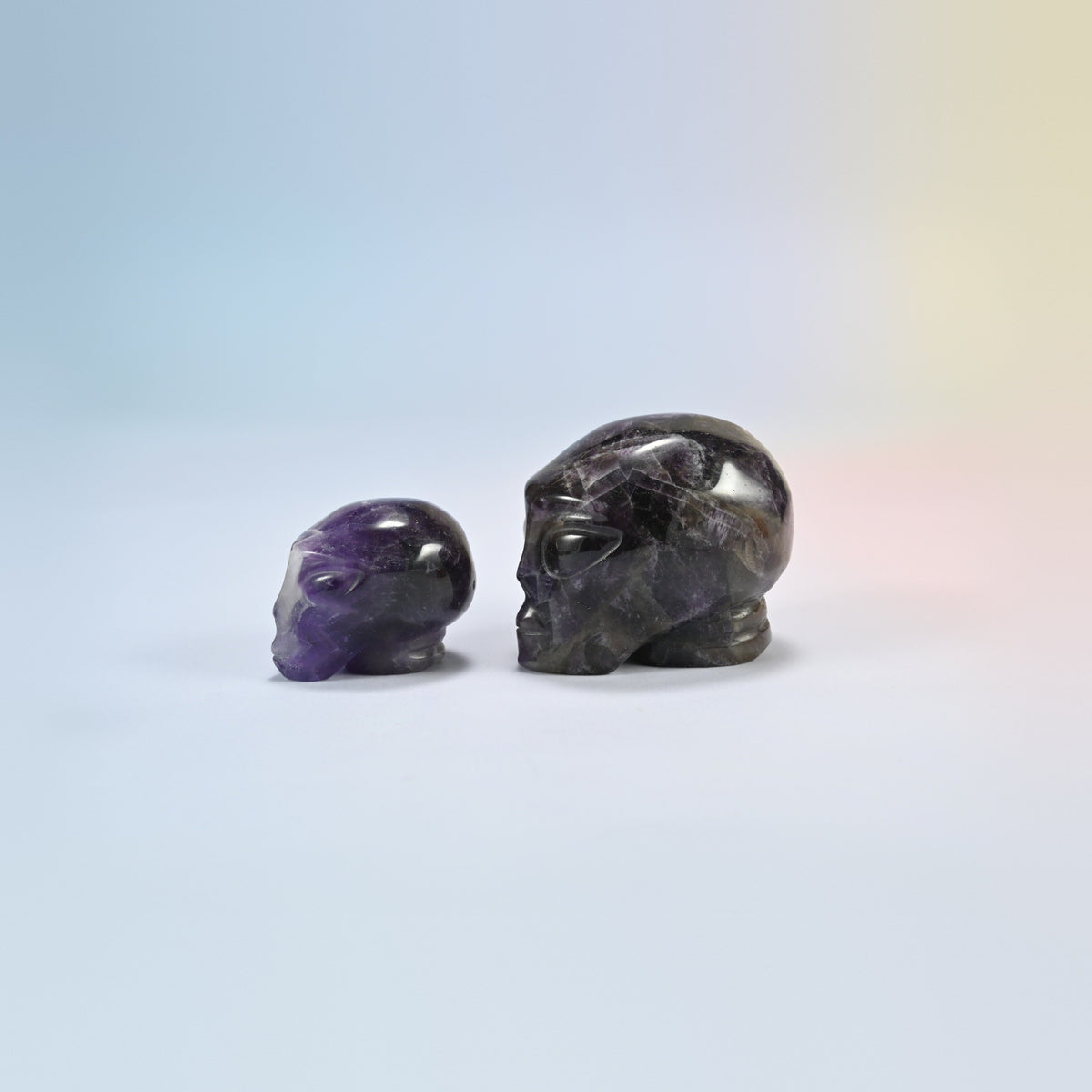 Two amethyst alien head crystal carvings, 1.5 inch and 2 inch, deep purple natural stone